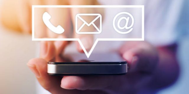 Close-up image of male hands using smartphone with icon telephone email mobile phone and address. Contact us connection and e-mail marketing concept